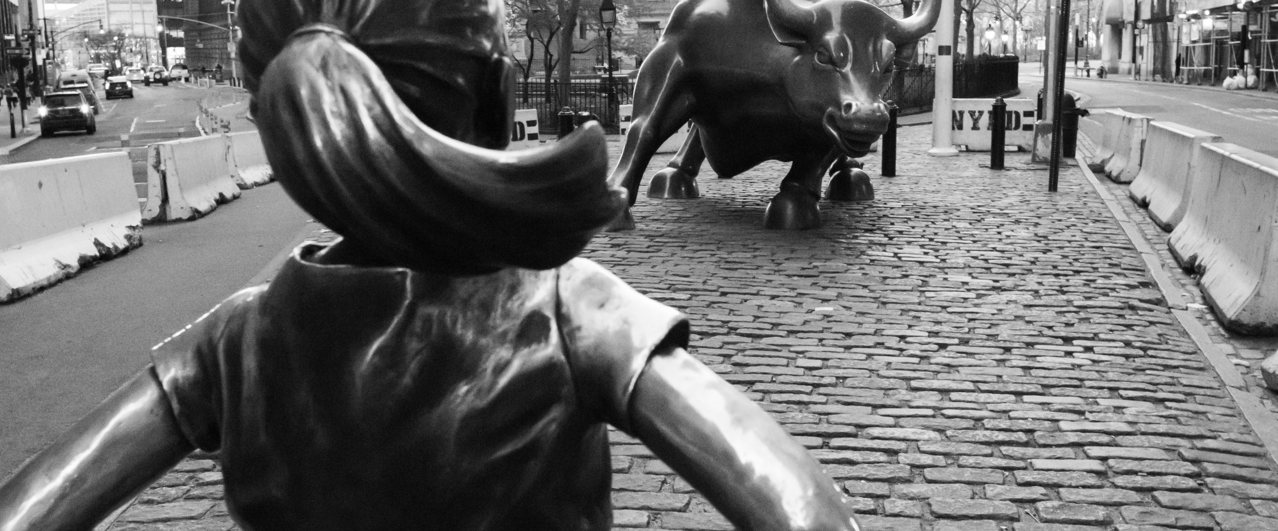 Fearless girl statue facing down the bull on Wall Street