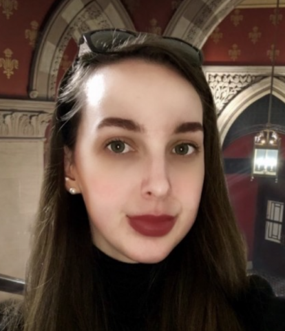 Lilly Streider, Grab Your Wallet Alliance board member, gazes at the camera, wearing a black turtleneck